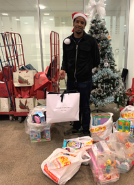 Man standing in front of Christmas tree with presents