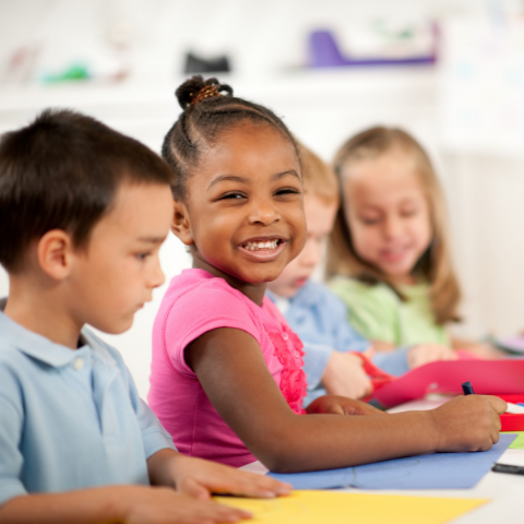 Group of children smiling in classroom
