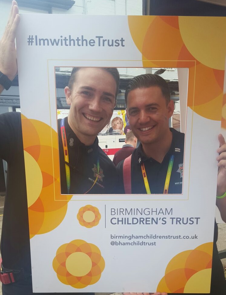 Two men framed by the Trust selfie board at the 2018 Pride event