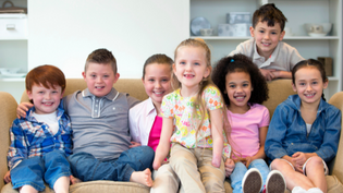 Group of Children on sofa smiling at the camera