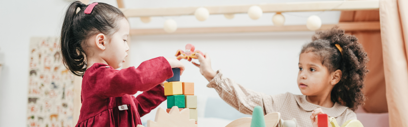 Two children building blocks together on a table