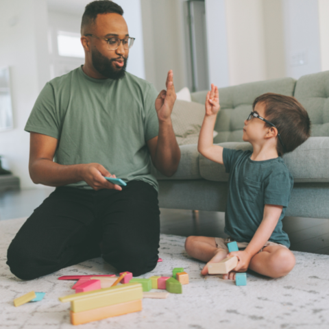 Man playing game with young boy in living room